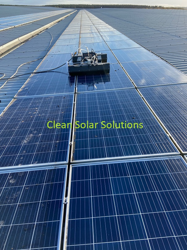 Roof mounted solar panels being cleaned with a robot